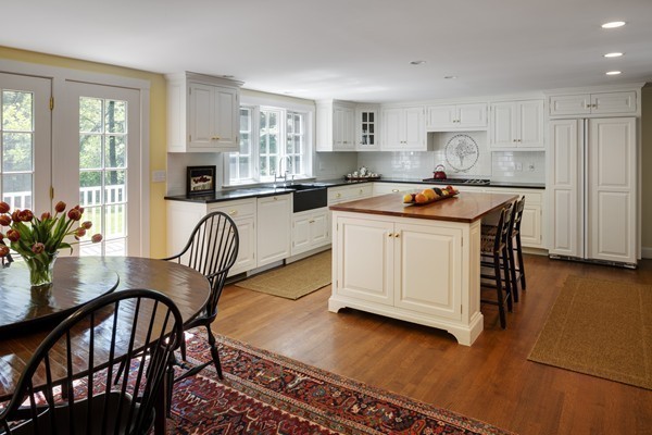 55 Willow Street Dover, MA 02030 - Photo 17 of 22 a kitchen with stainless steel appliances granite countertop a table chairs sink refrigerator and cabinets