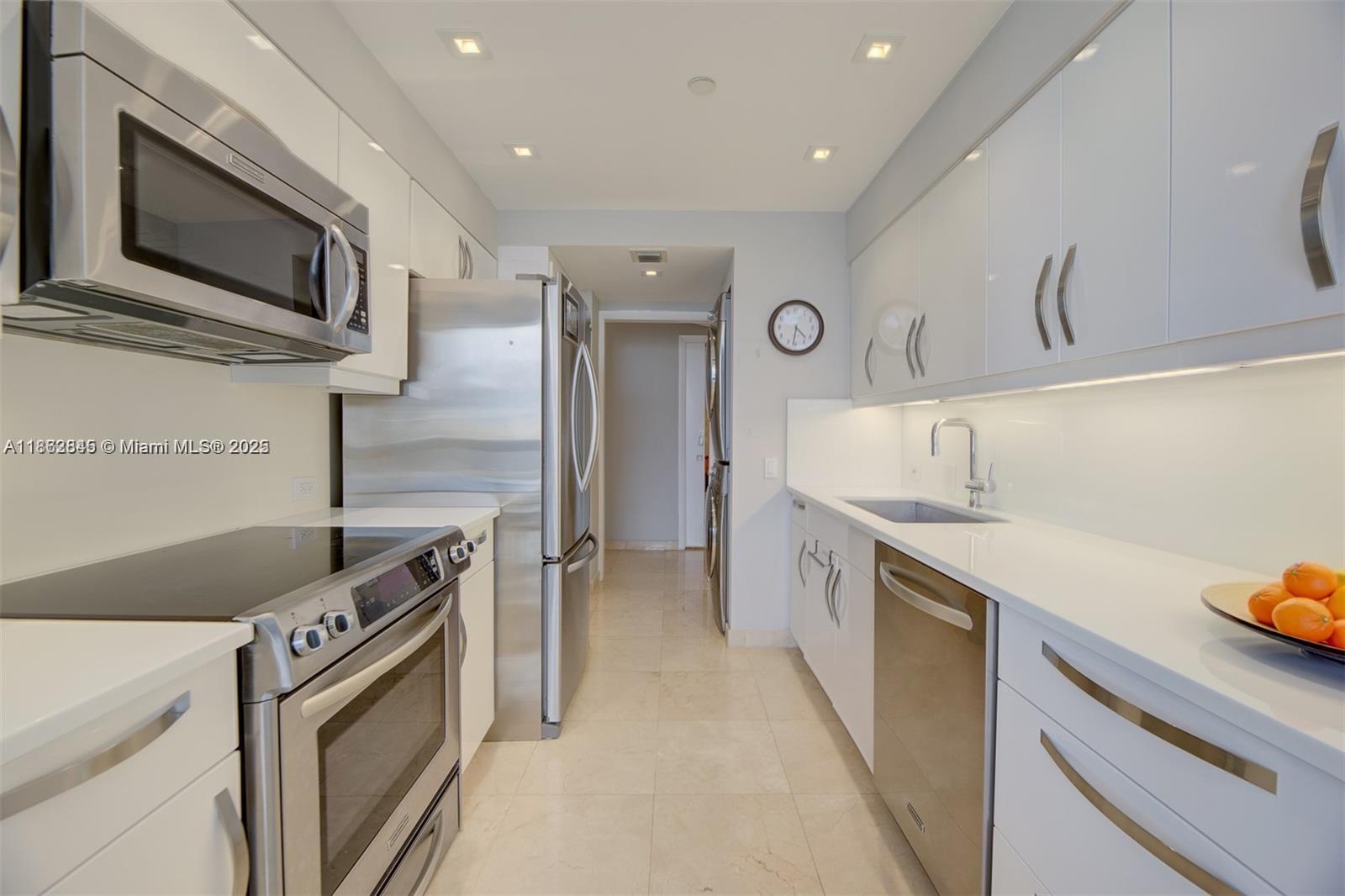 3000 East Island Boulevard, Unit 801 Aventura, FL 33160 - Photo 12 of 36 a kitchen with stainless steel appliances granite countertop a stove and a refrigerator
