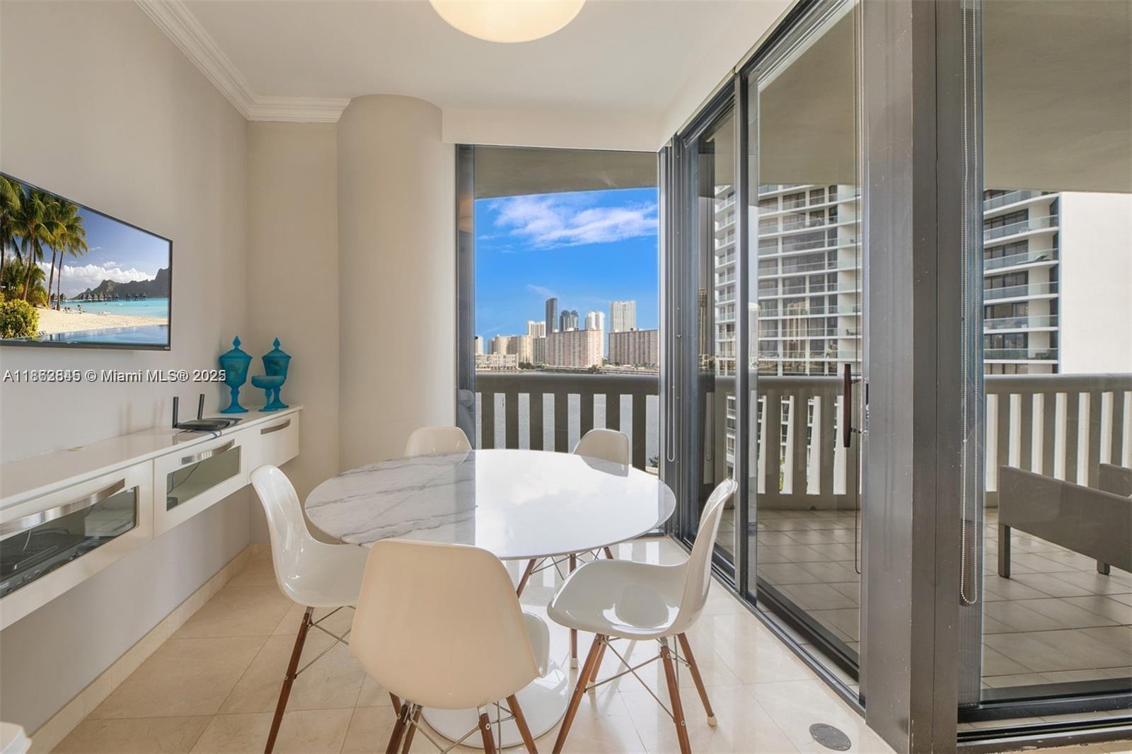 3000 East Island Boulevard, Unit 801 Aventura, FL 33160 - Photo 13 of 36 a view of a dining room with furniture a chandelier and wooden floor