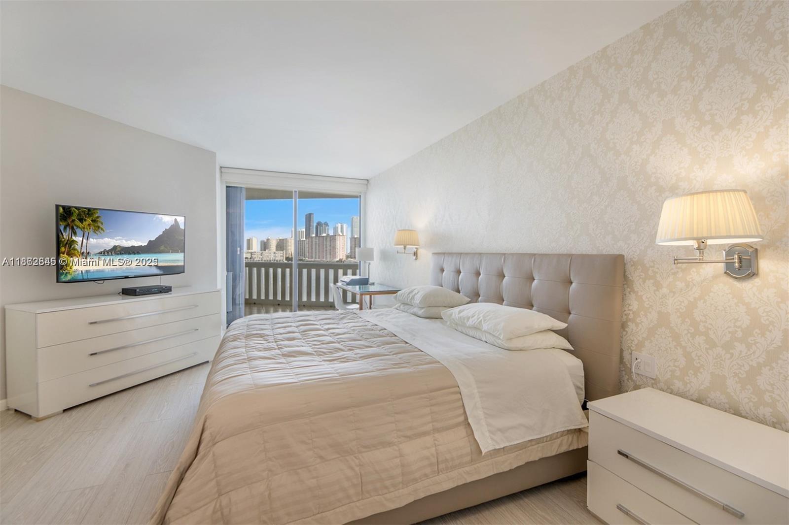 3000 East Island Boulevard, Unit 801 Aventura, FL 33160 - Photo 14 of 36 a bedroom with a bed and a painting on the wall