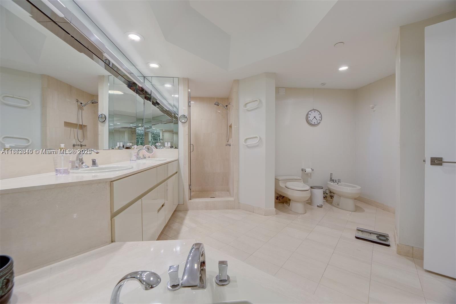 3000 East Island Boulevard, Unit 801 Aventura, FL 33160 - Photo 18 of 36 a spacious bathroom with a double vanity sink toilet and a mirror