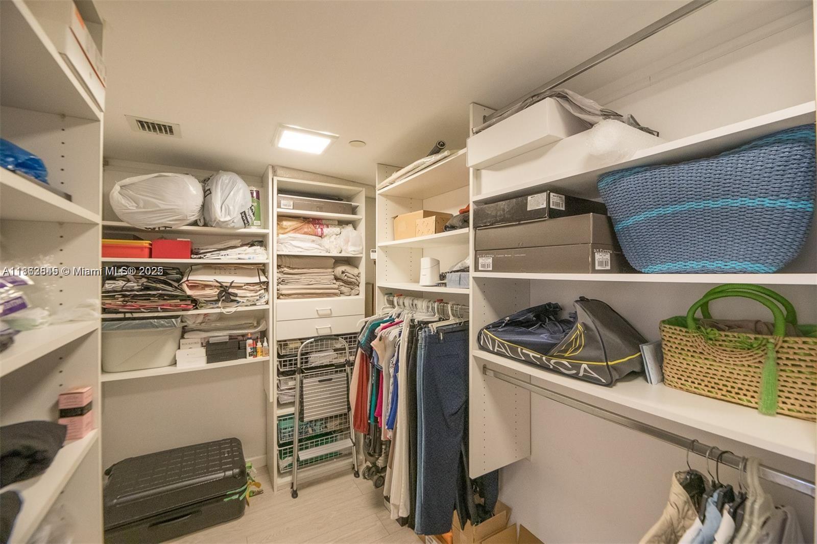 3000 East Island Boulevard, Unit 801 Aventura, FL 33160 - Photo 19 of 36 a view of walk in closet with clothes and shoes
