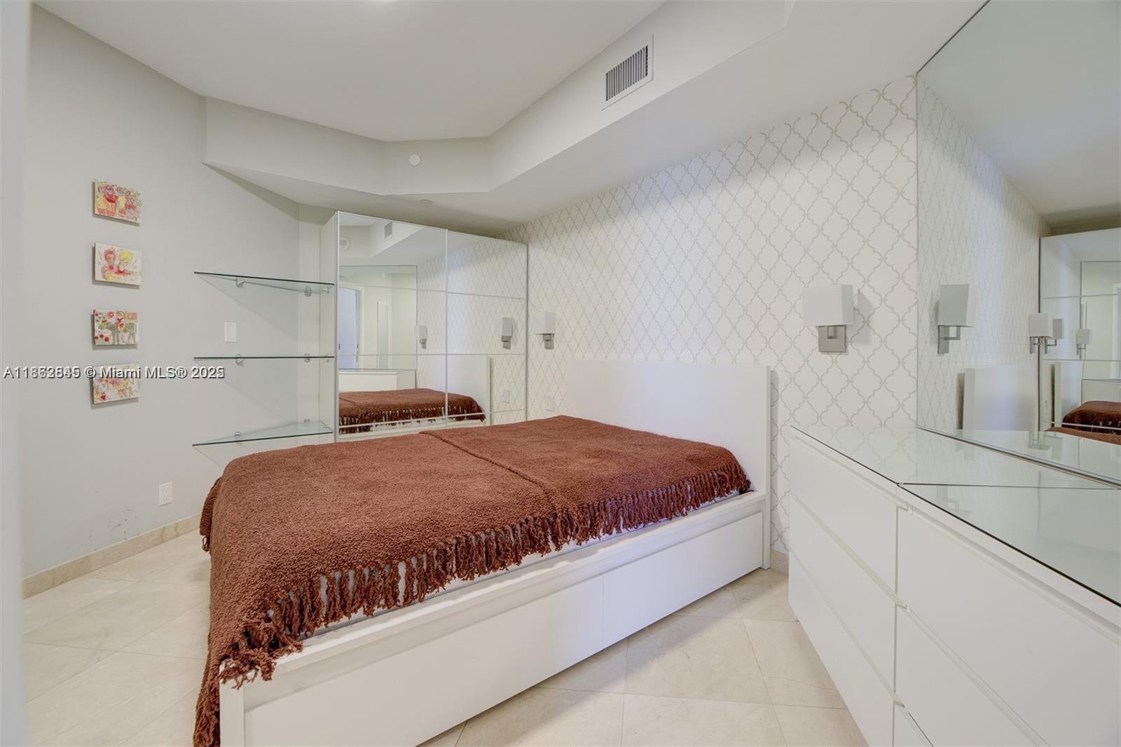3000 East Island Boulevard, Unit 801 Aventura, FL 33160 - Photo 24 of 36 a bedroom with a bed and a cabinets