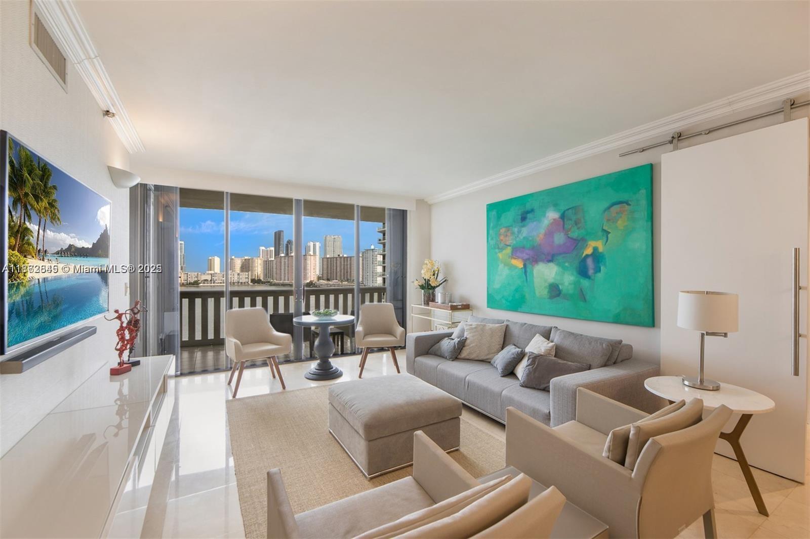 3000 East Island Boulevard, Unit 801 Aventura, FL 33160 - Photo 3 of 36 a living room with furniture and a flat screen tv