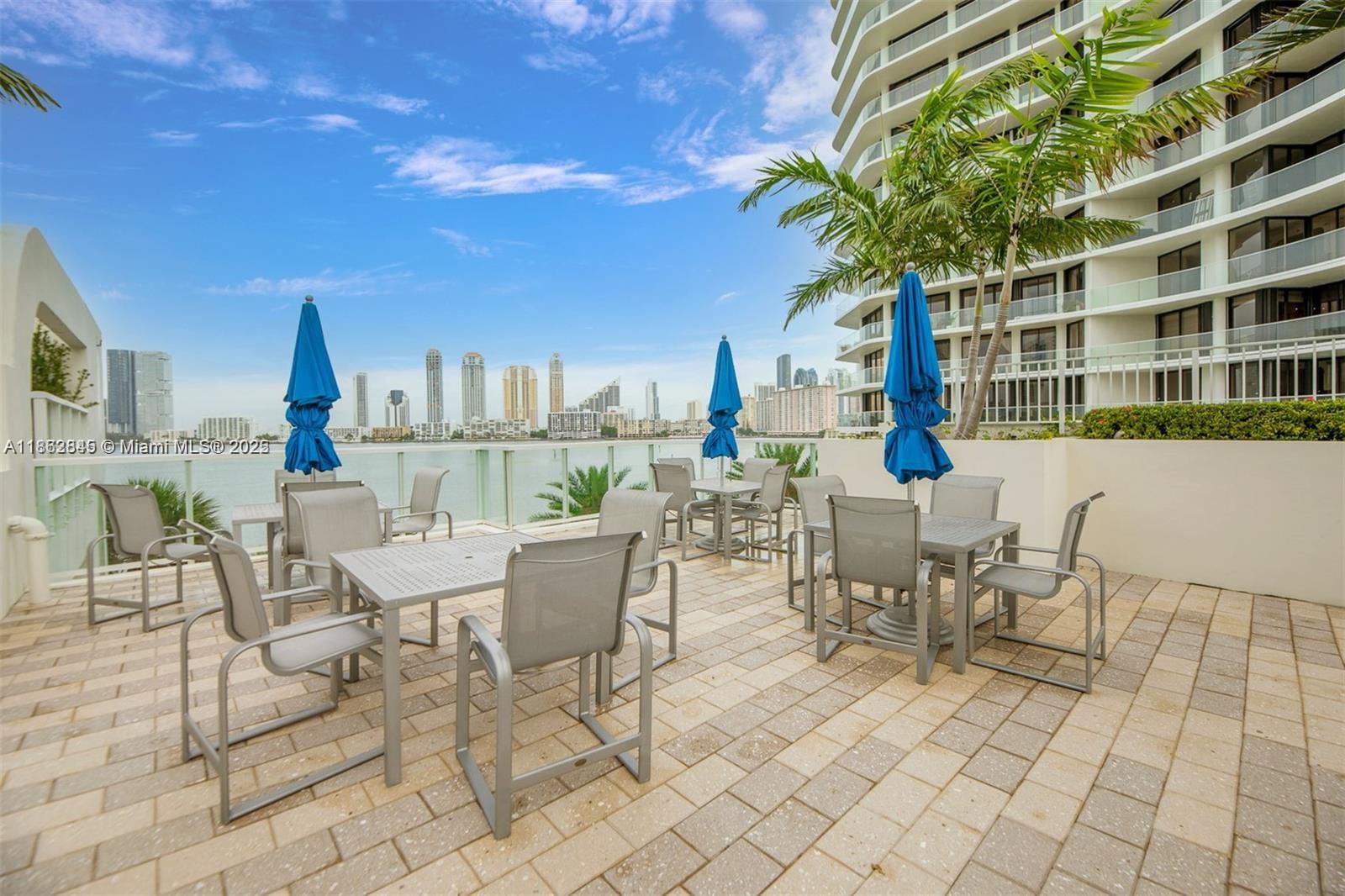 3000 East Island Boulevard, Unit 801 Aventura, FL 33160 - Photo 33 of 36 a view of a patio with a table and chairs and potted plants