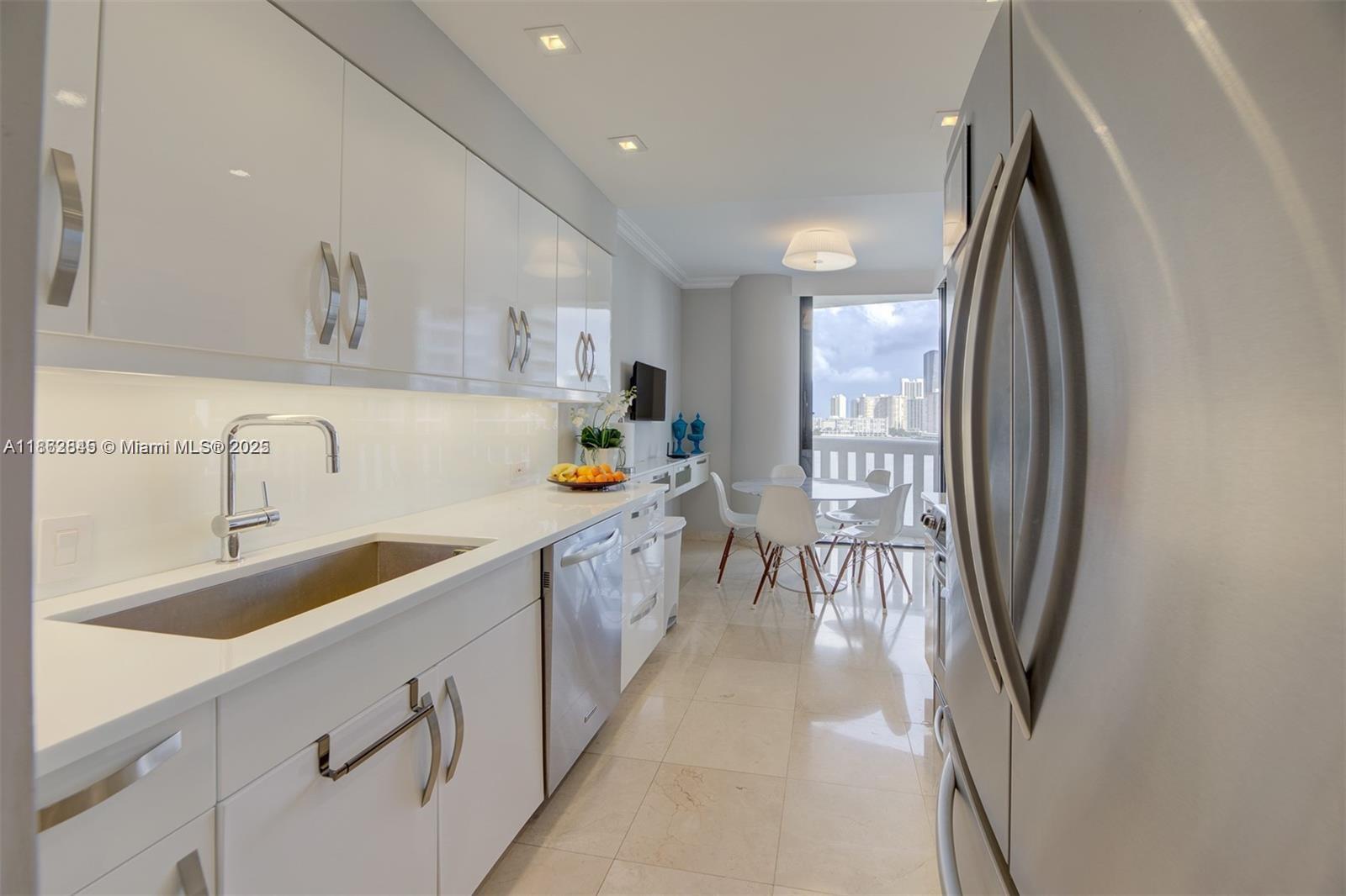 3000 East Island Boulevard, Unit 801 Aventura, FL 33160 - Photo 10 of 36 a kitchen that has a sink a refrigerator and a sink