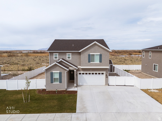 540 Lefty Lane Tooele, UT 84074 - Photo 34 of 48 Traditional home featuring an attached garage, stucco siding, driveway, and a gate