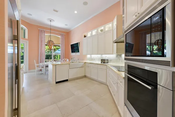 a kitchen with stainless steel appliances kitchen island granite countertop a refrigerator and a sink