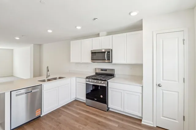 a kitchen with white cabinets and stainless steel appliances