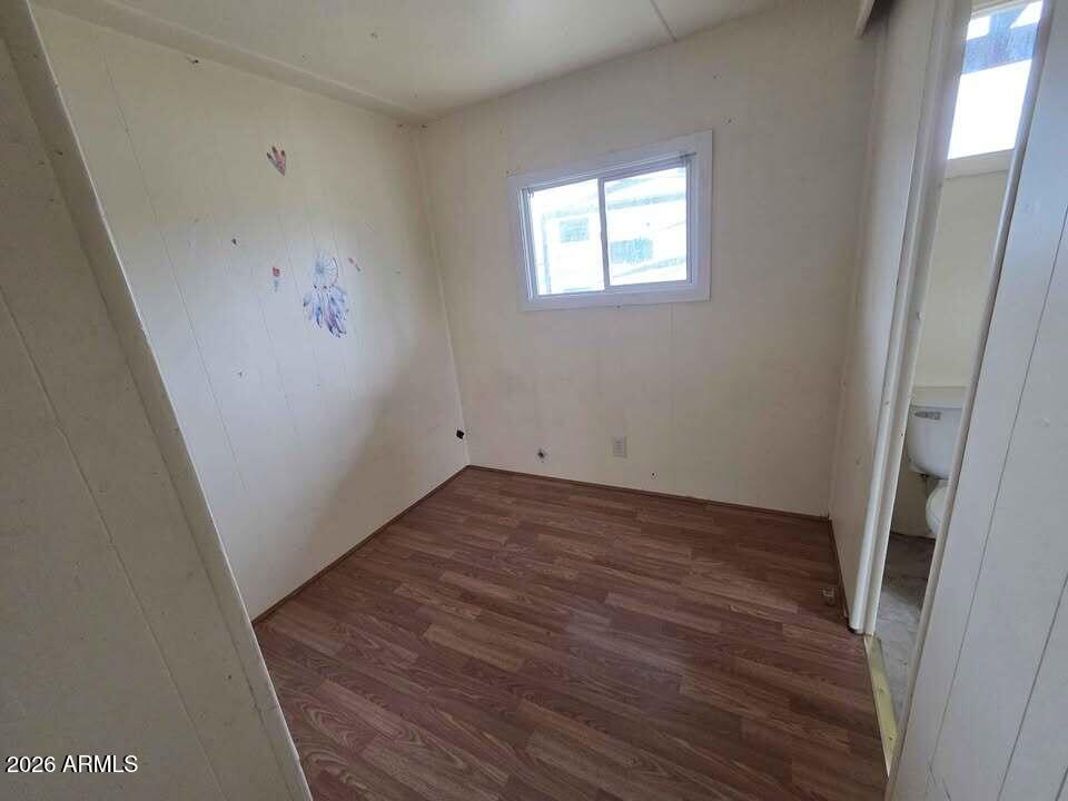 730 Tesota Quartzsite, AZ 85346 - Photo 9 of 15 an empty room with wooden floor and windows