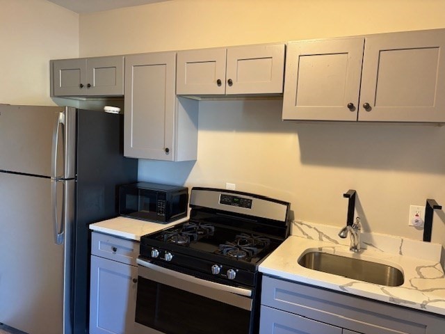 58 Bridge Street, Unit 2M Salem, MA 01970 - Photo 1 of 11 a kitchen with granite countertop a sink stove and refrigerator