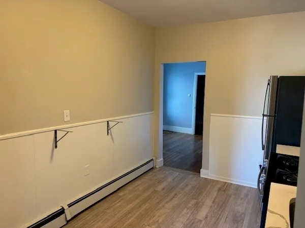 a view of empty room with wooden floor