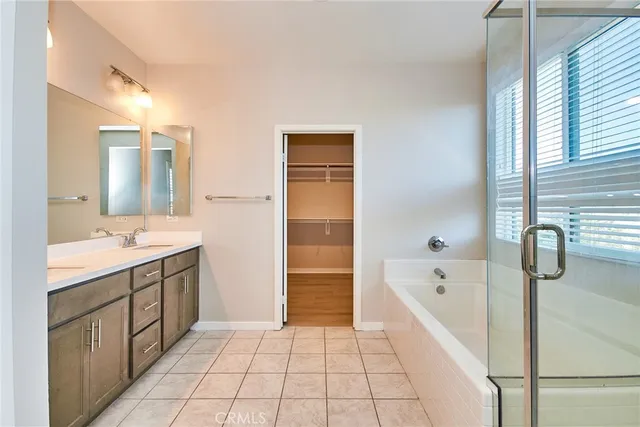 a bathroom with a tub sink and mirror