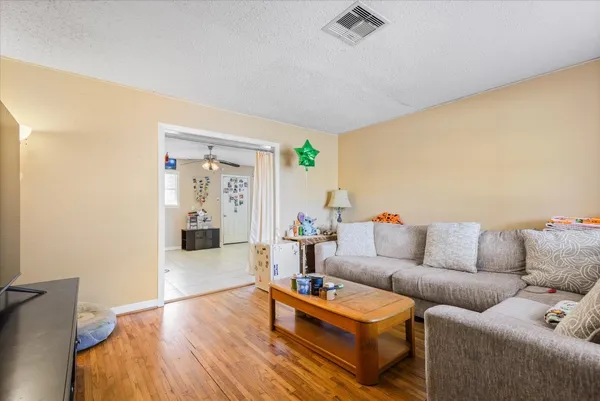 a living room with furniture and a wooden floor