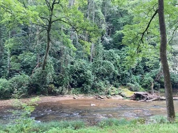 a view of a dirt road with trees in the background