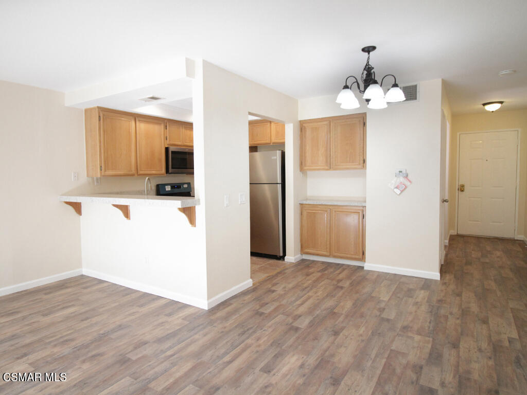2731 Erringer Road, Unit 79 Simi Valley, CA 93065 - Photo 7 of 13 wooden floor in an empty room with a kitchen