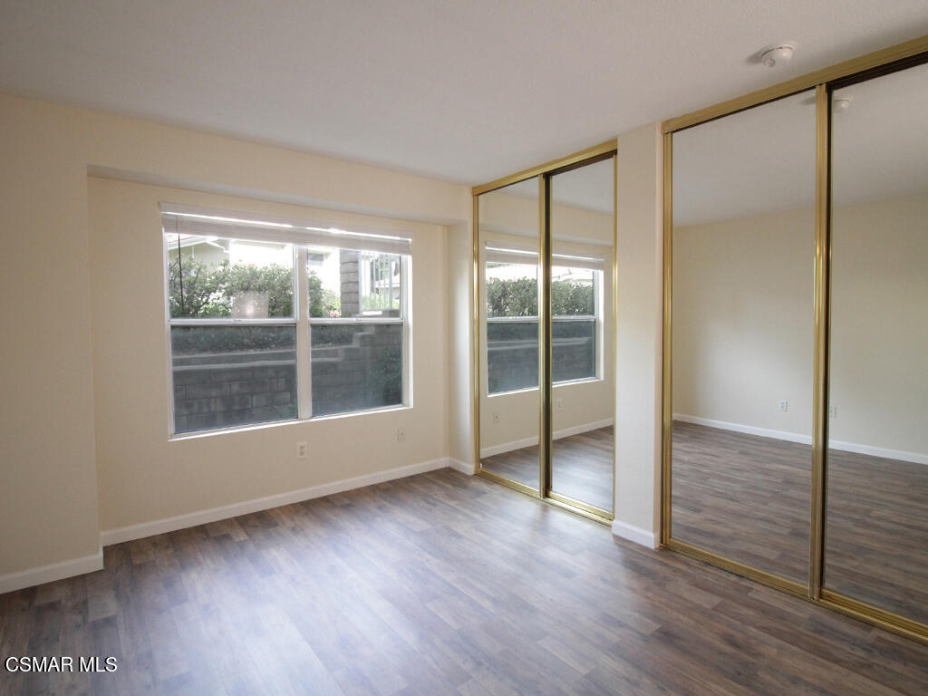 2731 Erringer Road, Unit 79 Simi Valley, CA 93065 - Photo 8 of 13 an empty room with wooden floor and windows
