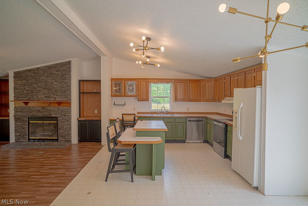 967 Buck Run Road Mineral Wells, WV 26150 - Photo 18 of 50 Spacious kitchen featuring a central island with bar seating, wood-finish upper cabinetry, green lower cabinetry, and stainless steel appliances