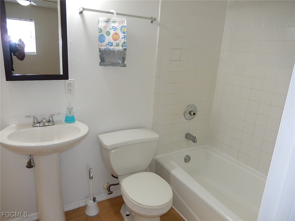 3309 2nd Street Southwest Lehigh Acres, FL 33976 - Photo 11 of 17 a white toilet sitting next to a bathroom sink