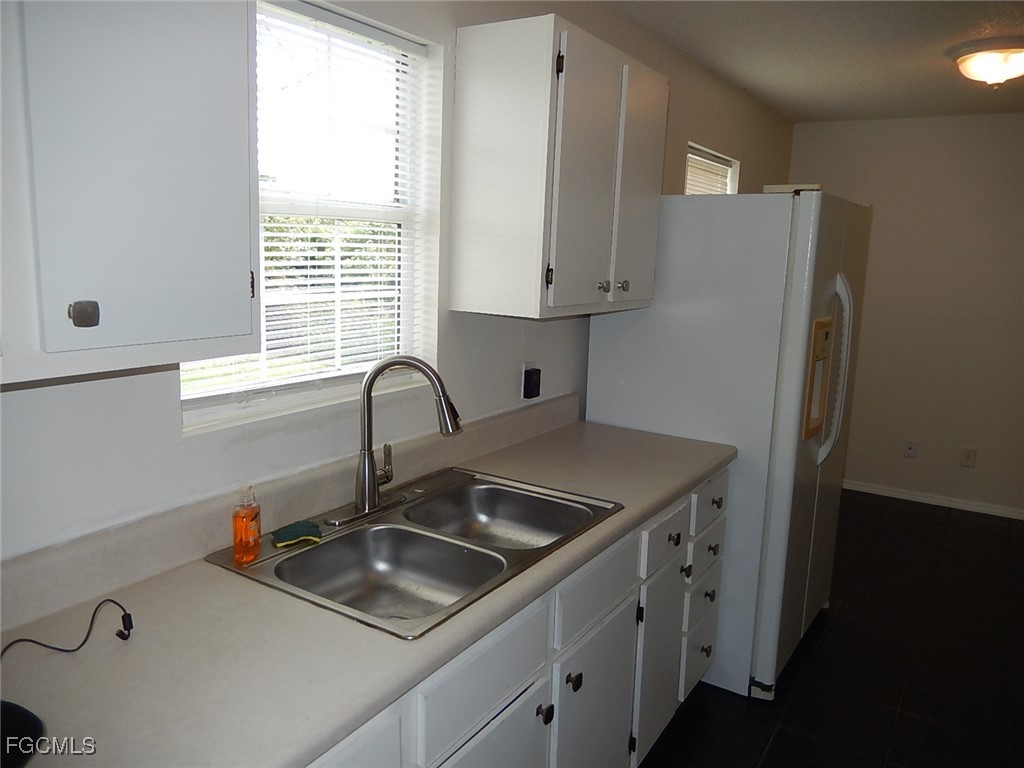 3309 2nd Street Southwest Lehigh Acres, FL 33976 - Photo 5 of 17 a kitchen with stainless steel appliances granite countertop a sink stove and refrigerator