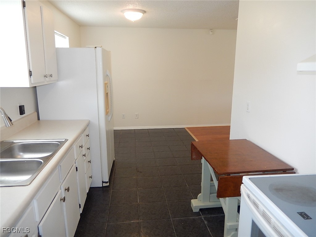 3309 2nd Street Southwest Lehigh Acres, FL 33976 - Photo 6 of 17 a kitchen with a sink stove and cabinets