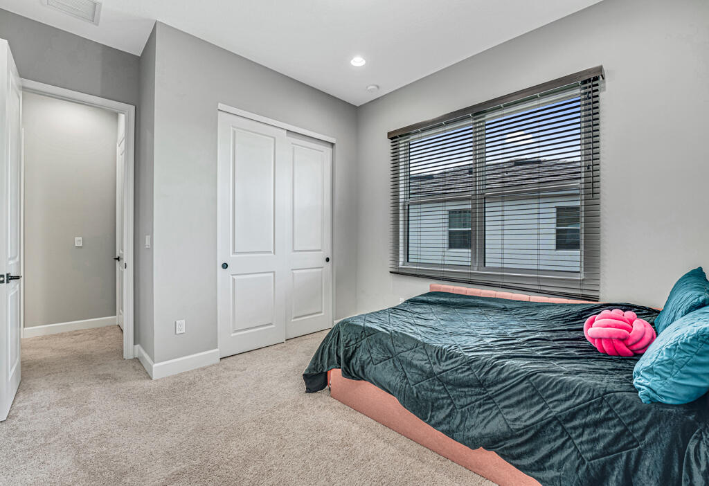 5482 Macoon Way Westlake, FL 33470 - Photo 23 of 69 a bedroom with a bed and a chandelier