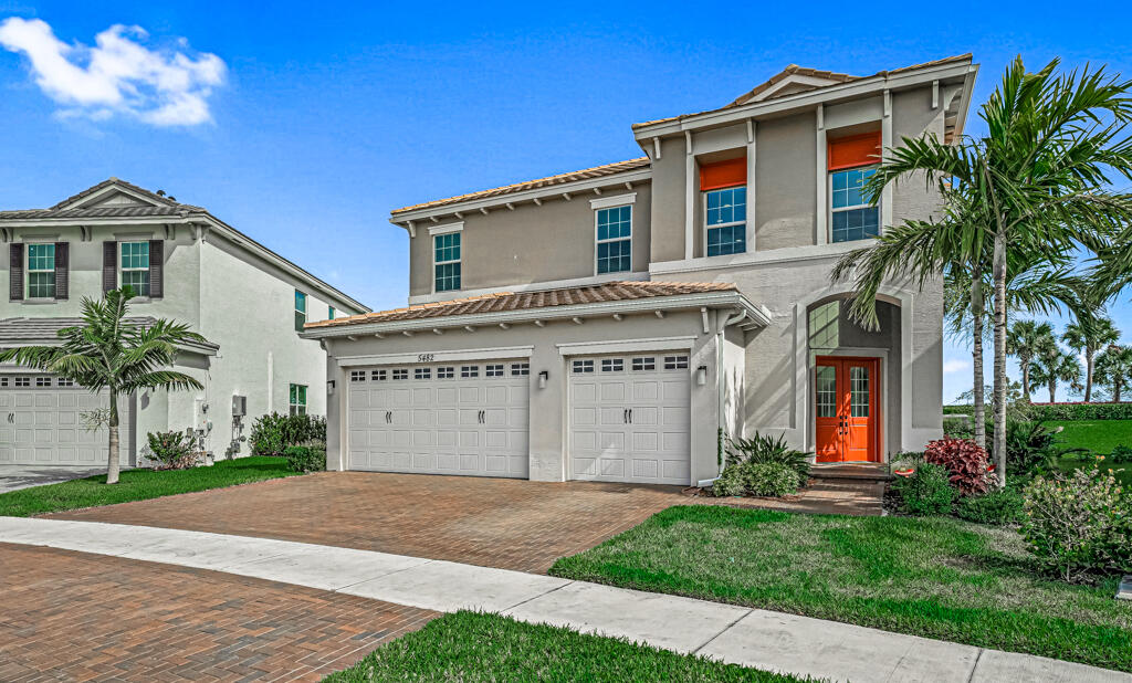 5482 Macoon Way Westlake, FL 33470 - Photo 32 of 69 a view of a white house with a large windows and a yard with plants and large trees