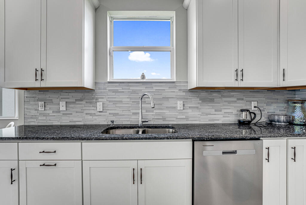 5482 Macoon Way Westlake, FL 33470 - Photo 35 of 69 a kitchen with granite countertop white cabinets and a sink