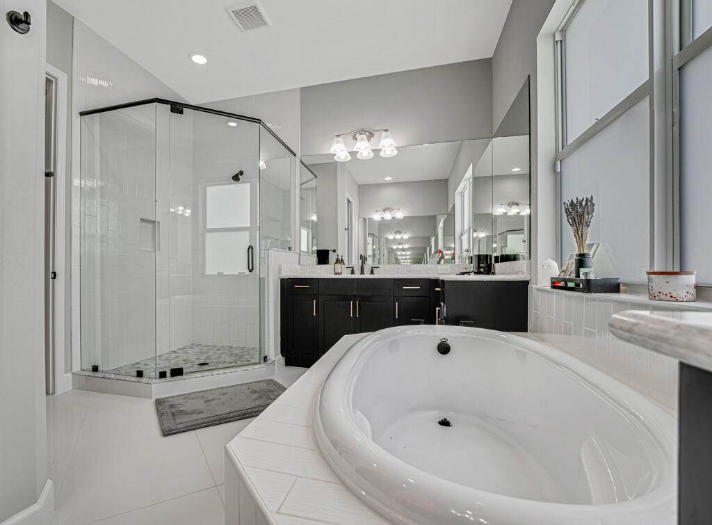 5482 Macoon Way Westlake, FL 33470 - Photo 40 of 69 a large bathroom with a tub a sink and a mirror