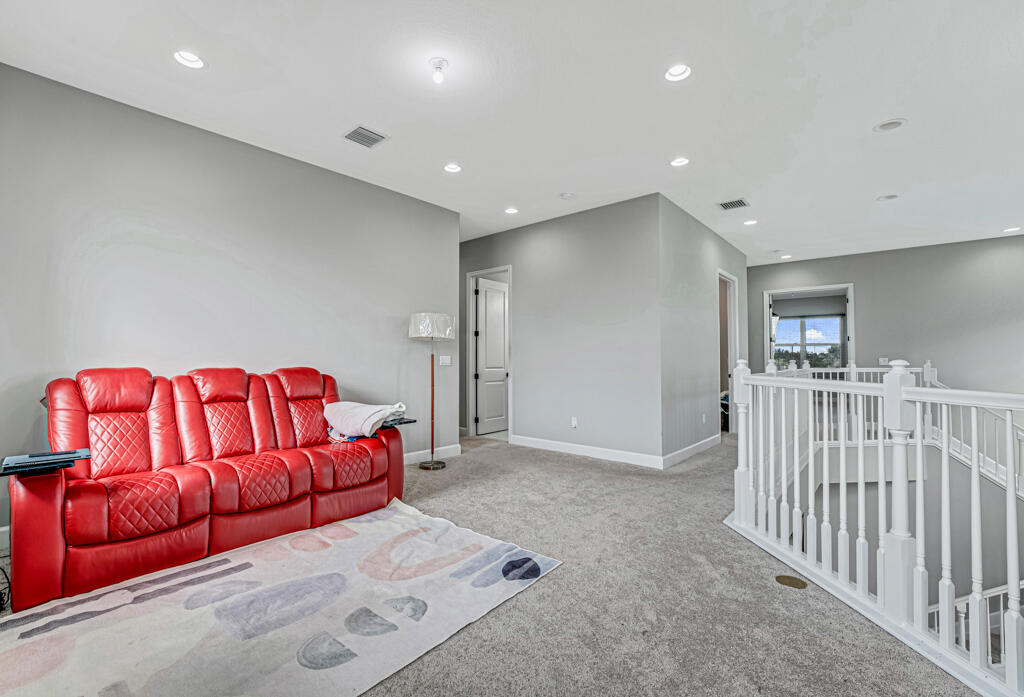 5482 Macoon Way Westlake, FL 33470 - Photo 54 of 69 a living room with a couch and a book shelf
