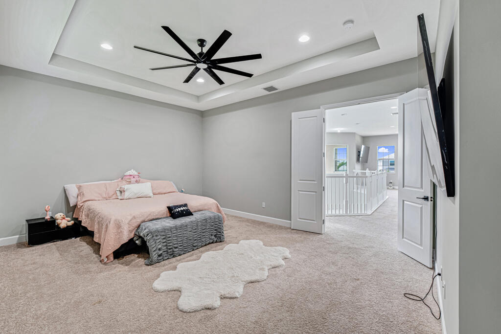 5482 Macoon Way Westlake, FL 33470 - Photo 56 of 69 a spacious bedroom with a bed and a ceiling fan