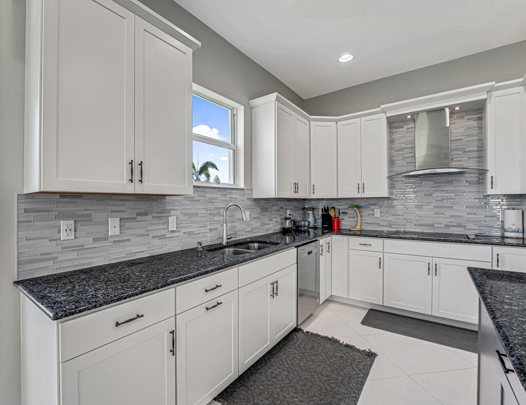 5482 Macoon Way Westlake, FL 33470 - Photo 8 of 69 a kitchen with granite countertop white cabinets and white appliances