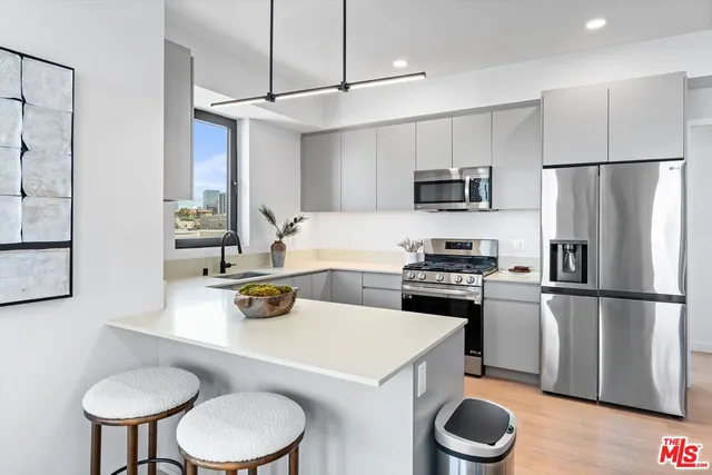 a kitchen with a refrigerator a stove a microwave and wooden floor