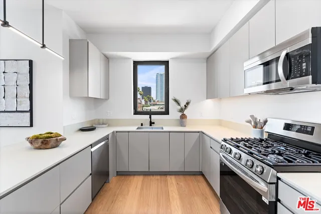 a kitchen with stainless steel appliances a sink dishwasher stove and oven with cabinets