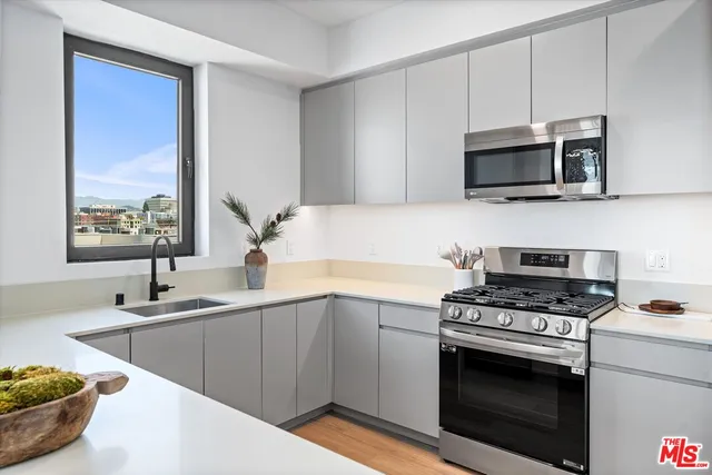 a kitchen with stainless steel appliances a sink a stove and microwave