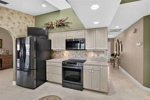 a kitchen with stainless steel appliances granite countertop a refrigerator a stove and a sink