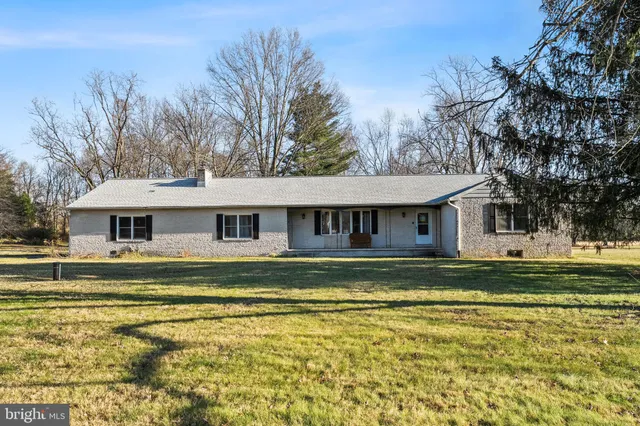 a view of a house with a big yard and large trees