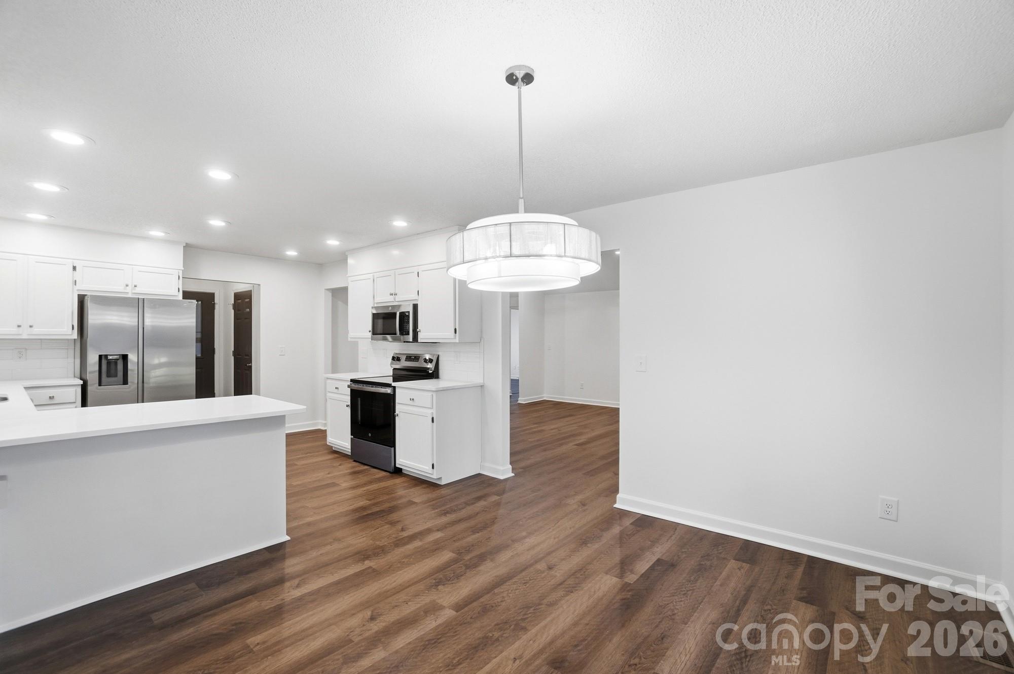 4437 Lake Shore Road North Denver, NC 28037 - Photo 11 of 43 a view of a kitchen with kitchen island a counter top space stainless steel appliances wooden floor and a view of kitchen
