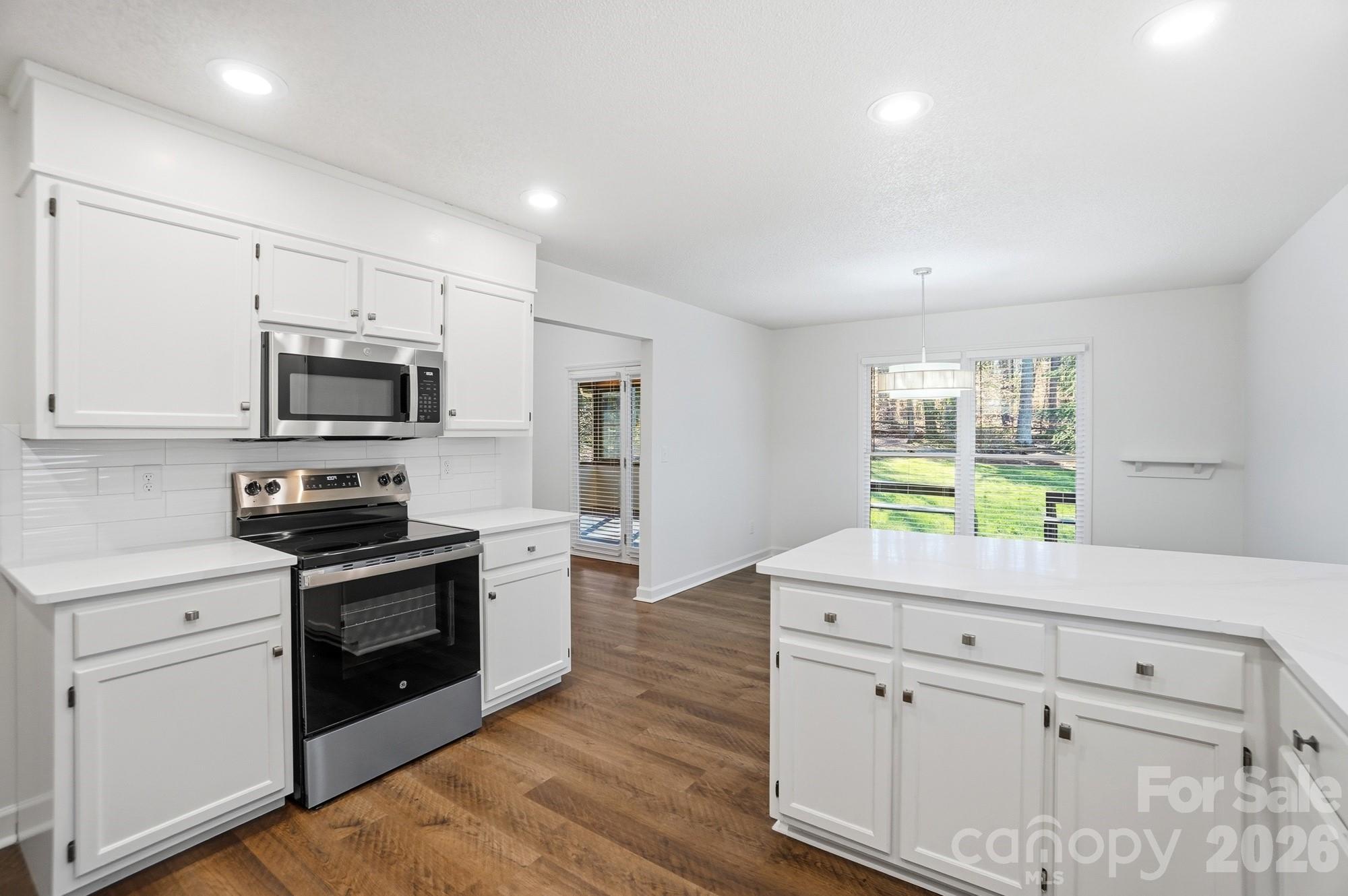 4437 Lake Shore Road North Denver, NC 28037 - Photo 4 of 43 a kitchen with white cabinets appliances and a window