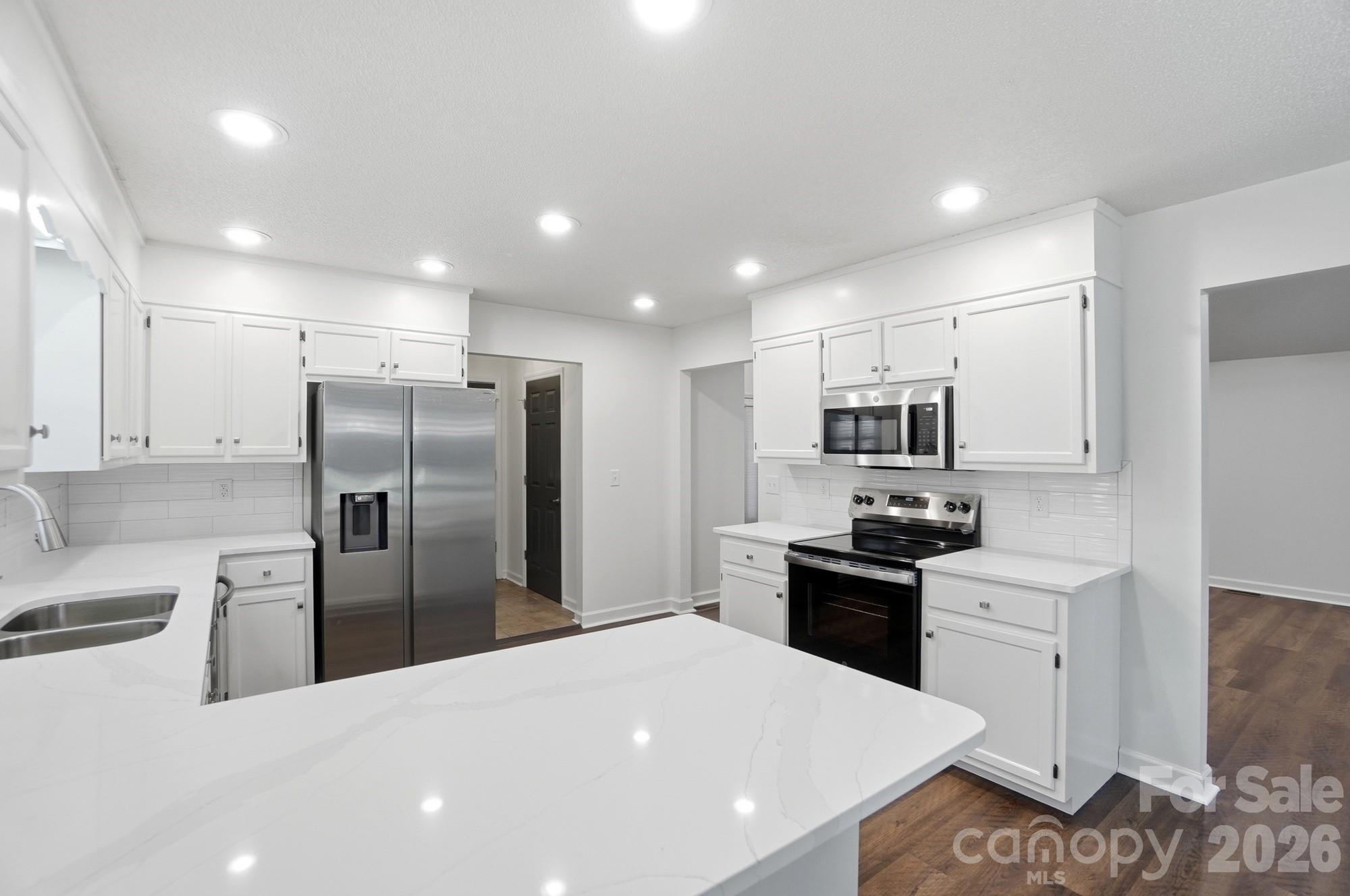 4437 Lake Shore Road North Denver, NC 28037 - Photo 8 of 43 a kitchen with stainless steel appliances kitchen island granite countertop a refrigerator a stove a sink a microwave and white cabinets with wooden floor