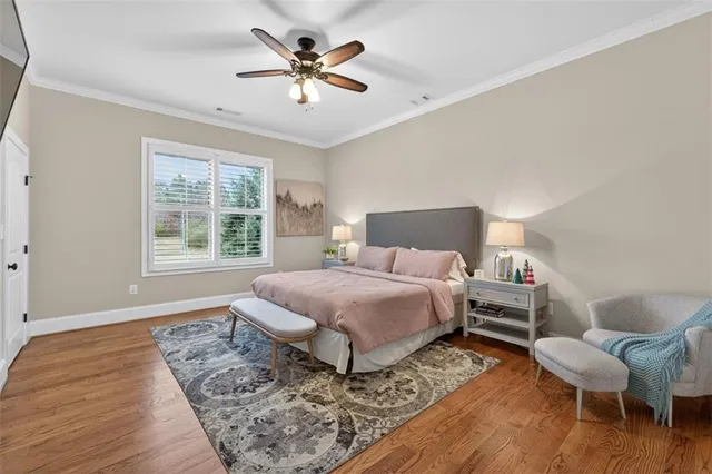 a bedroom with a bed a chair and a large window