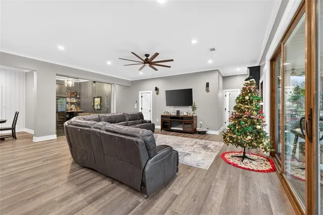 a kitchen with stainless steel appliances kitchen island granite countertop a refrigerator a stove a sink dishwasher and a dining table with wooden floor