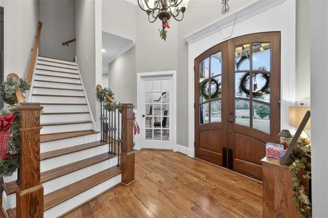 a living room with wooden floor and large windows