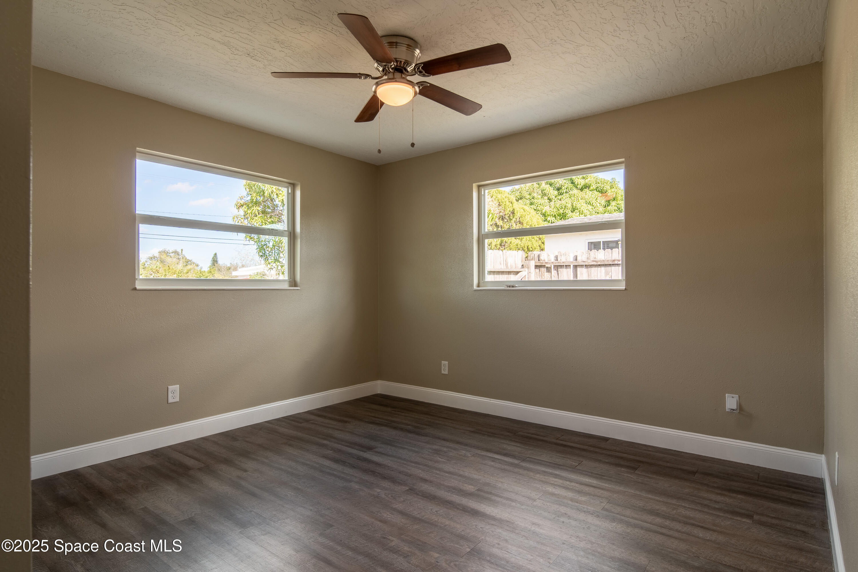 1705 Sarno Acc Melbourne, FL 32935 - Photo 22 of 40 a view of an empty room with wooden floor and a window