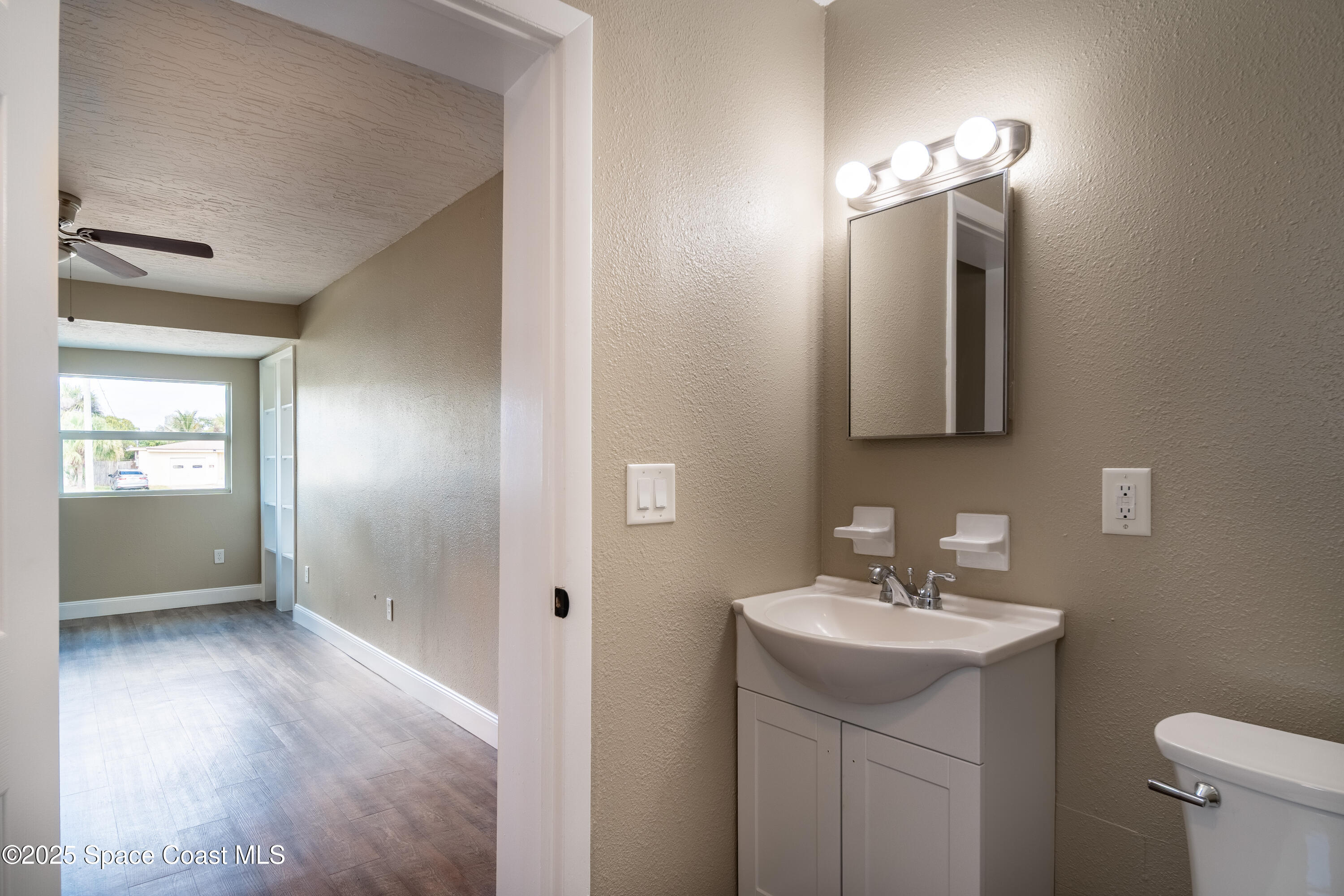 1705 Sarno Acc Melbourne, FL 32935 - Photo 28 of 40 a bathroom with a sink a light fixture and a mirror