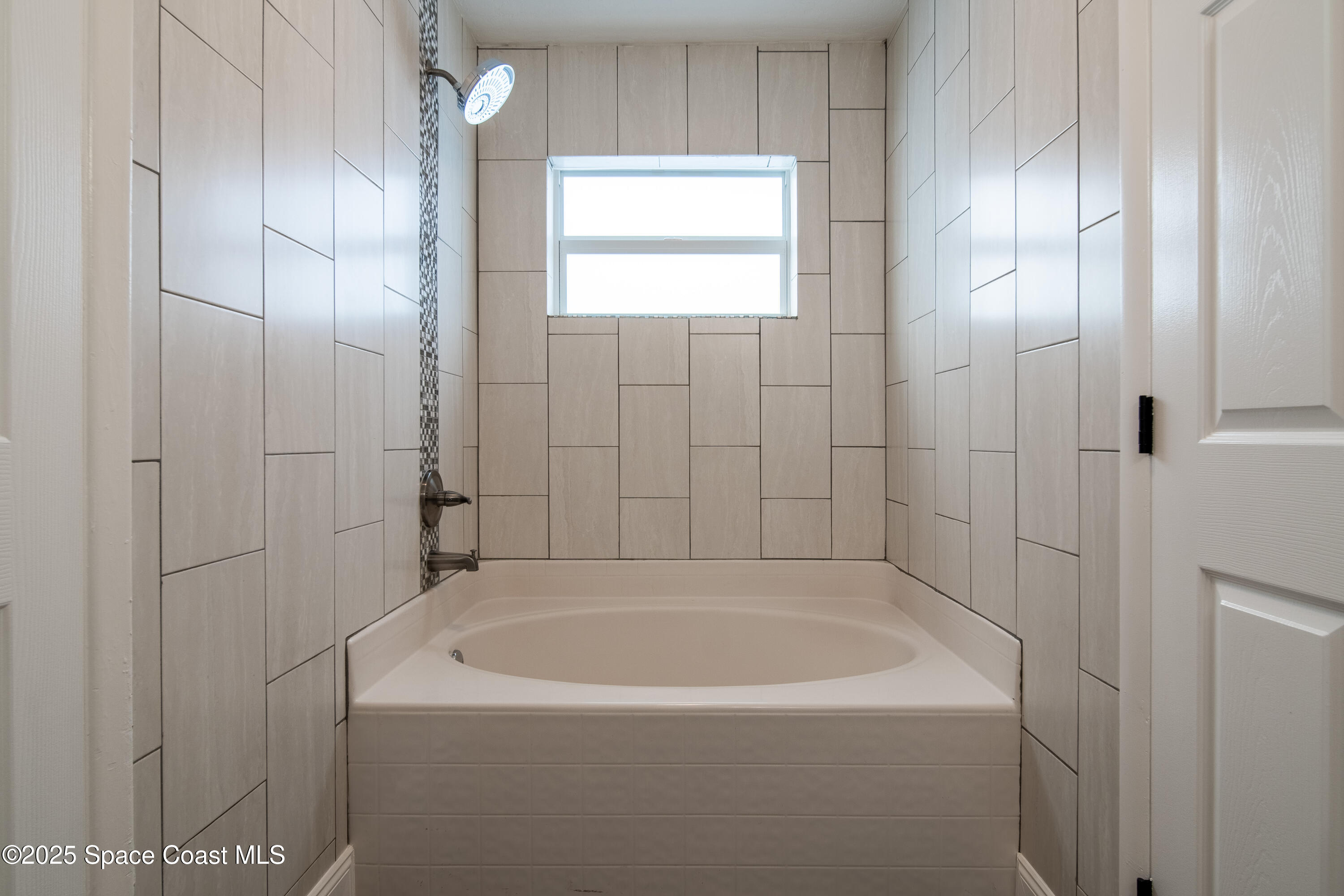 1705 Sarno Acc Melbourne, FL 32935 - Photo 29 of 40 a white bath tub sitting in a bathroom next to a window