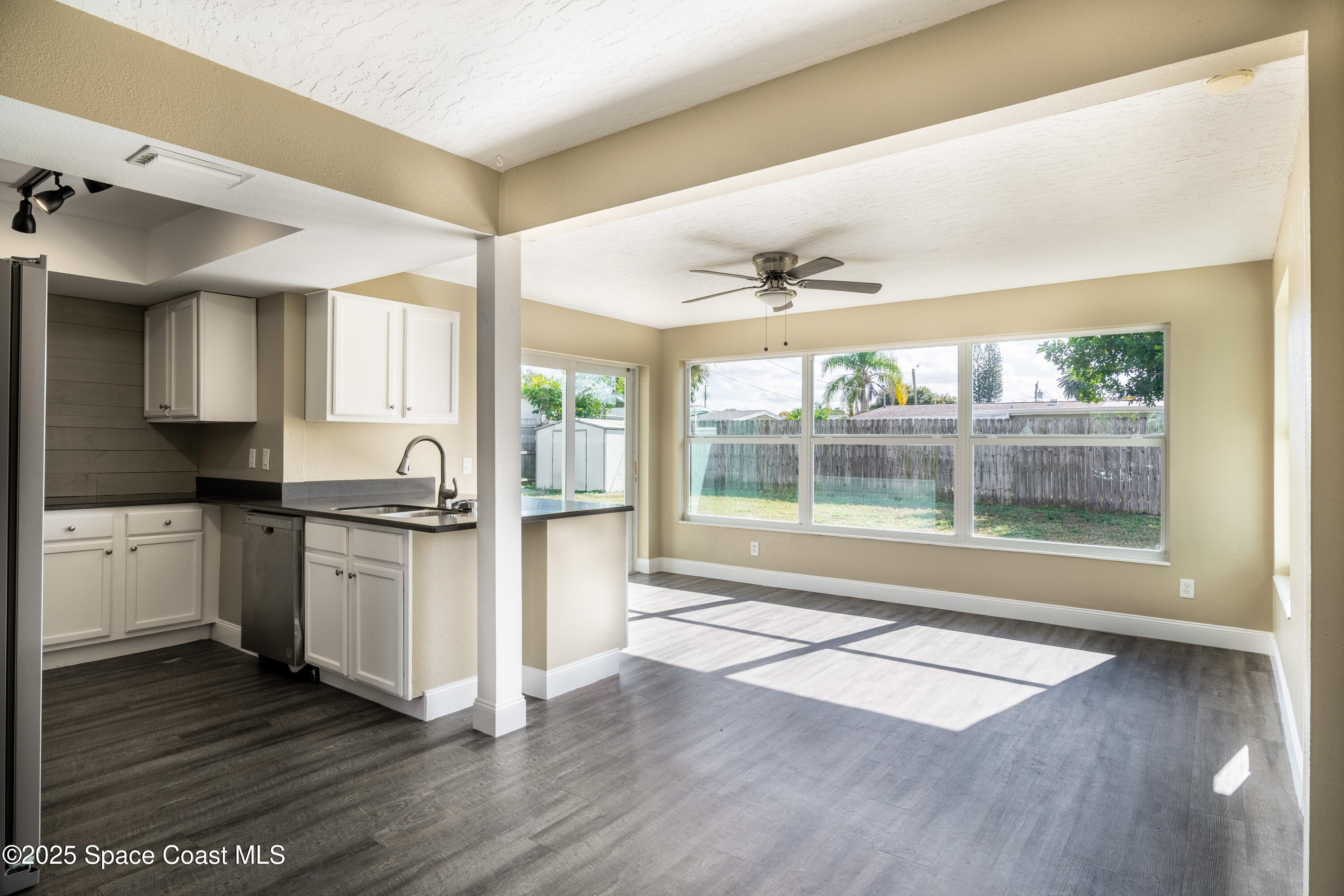 1705 Sarno Acc Melbourne, FL 32935 - Photo 30 of 40 a open kitchen with granite countertop a stove top oven a sink and white cabinets with wooden floor