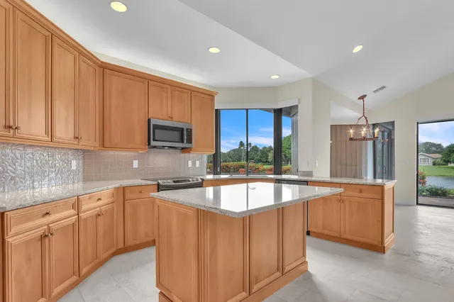 a kitchen with stainless steel appliances granite countertop a stove top oven a refrigerator a sink and dishwasher
