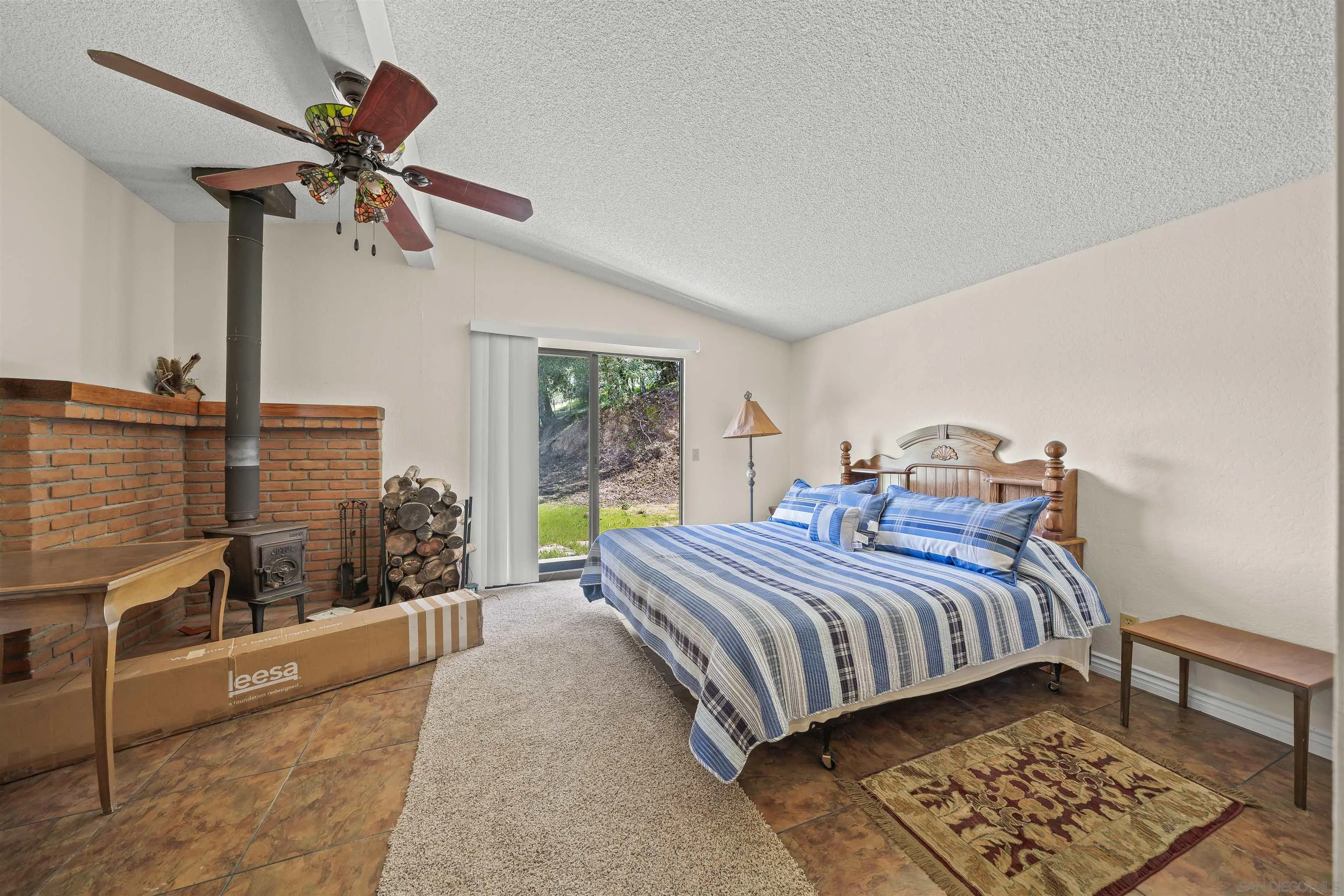 2464 Wynola Road Julian, CA 92036 - Photo 35 of 50 a bedroom with a bed a couch and a chandelier