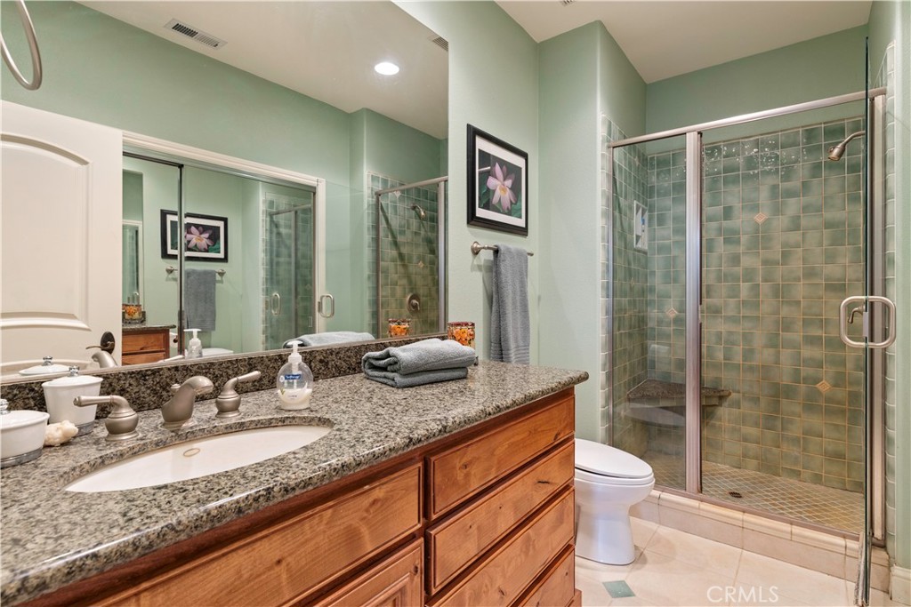 8664 Seigler Springs Road Kelseyville, CA 95451 - Photo 28 of 75 a bathroom with a granite countertop sink mirror vanity and toilet